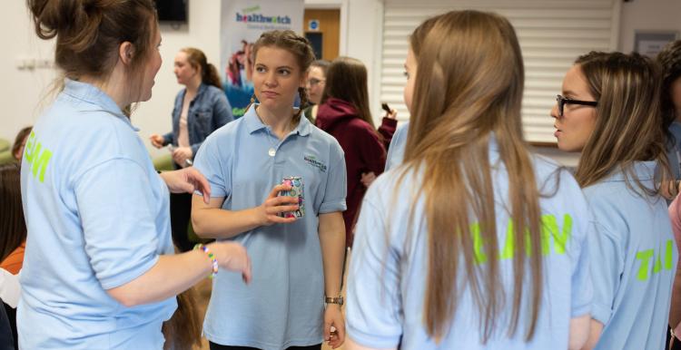 Group of young girls stood in a circle chatting 