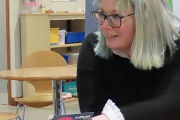 A member of Healthwatch providing an information leaflet to a member of the public in a community hub